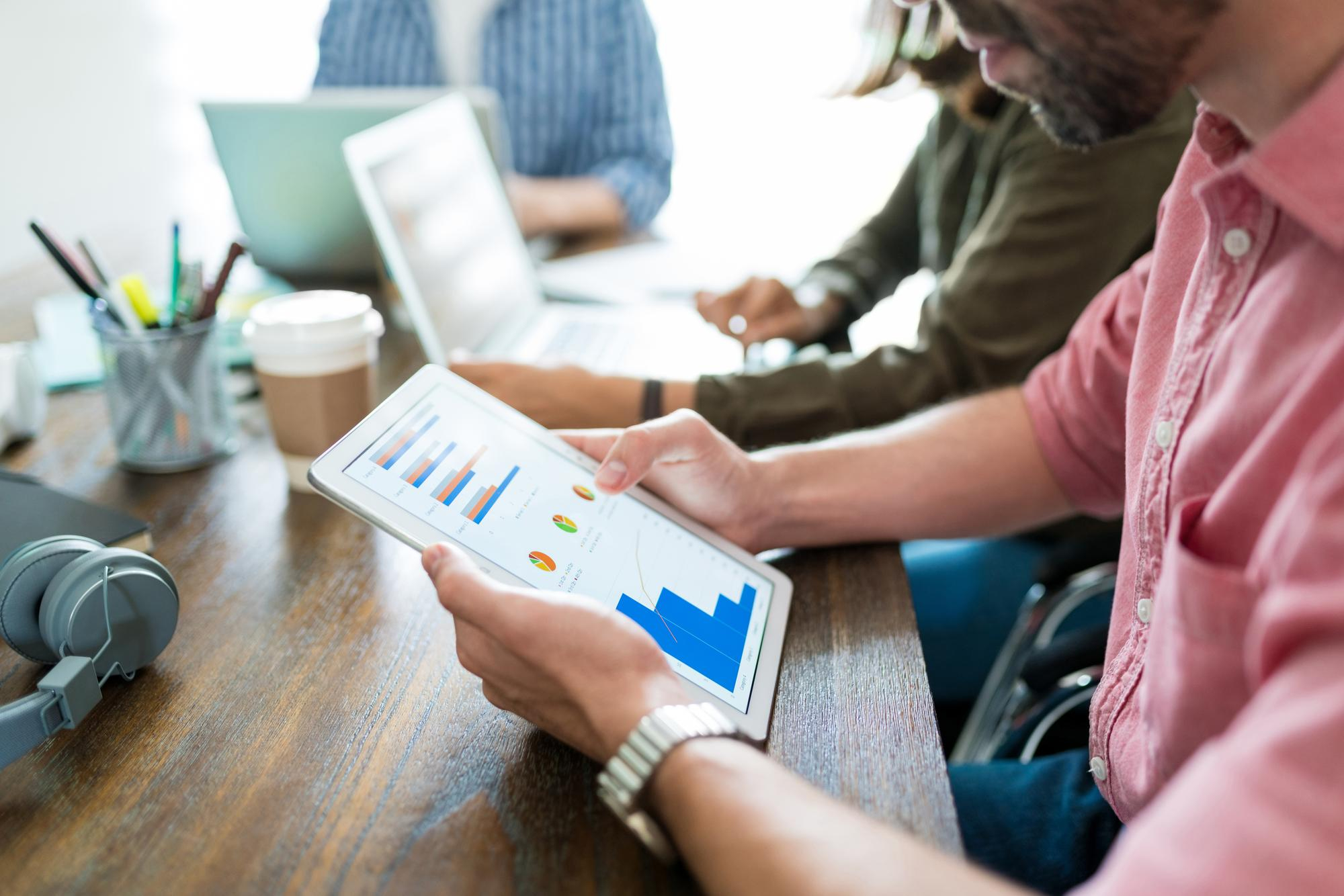 A man looks at an analytics dashboard on an iPad.